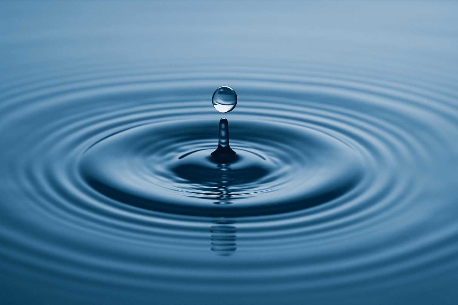 Water droplet creating ripples in a pond